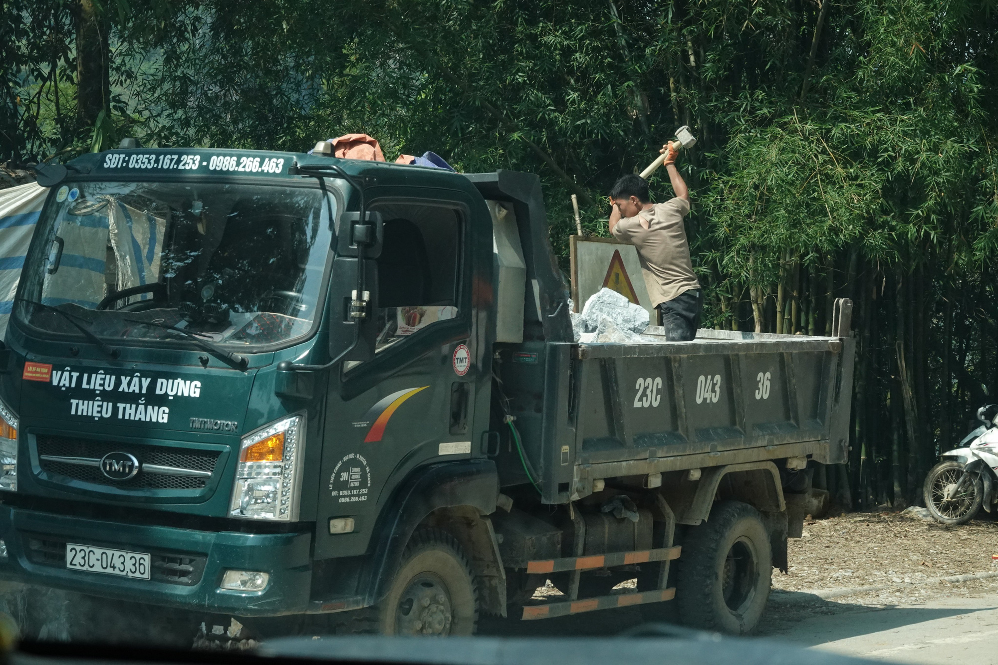 Đập đá ngay trên xe tải đậu giữa trung tâm thị trấn Yên Minh, trước khi đem đi tiêu thụ. (Ảnh: Nhóm PV)